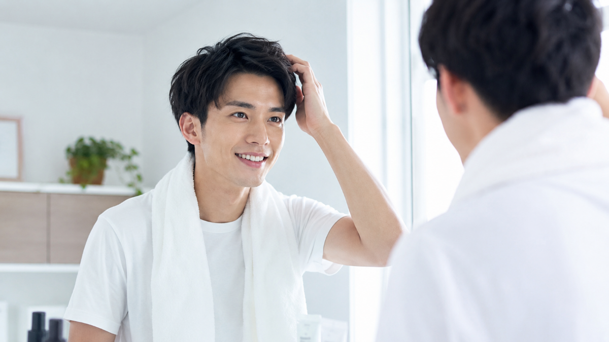 鏡の前で髪を整える清潔感のある男性